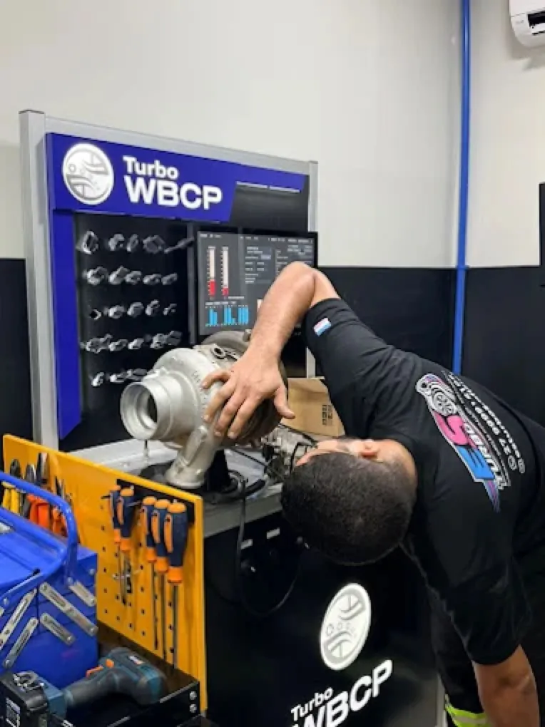 Técnico da ES Turbos operando equipamento de bancada